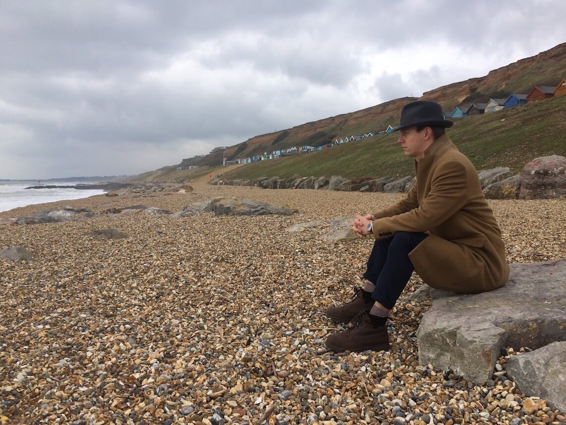 Samu sitting on a stone on the seaside